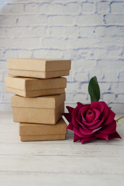 Pile de coffret cadeau et fleur rose sur table