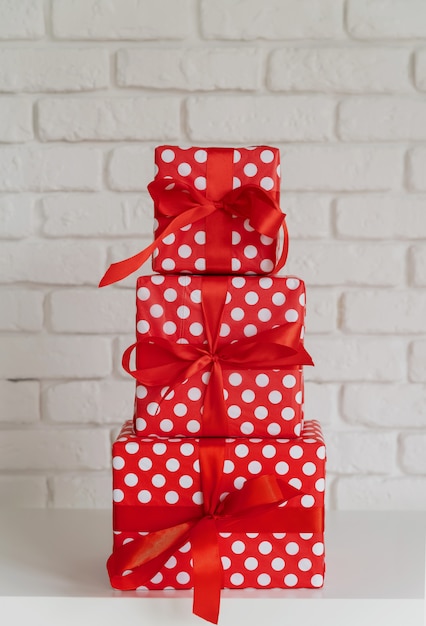 Pile de coffrets cadeaux rouges sur mur blanc