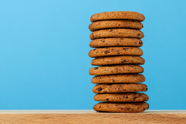 Pile de cookies aux pépites de chocolat sur fond bleu