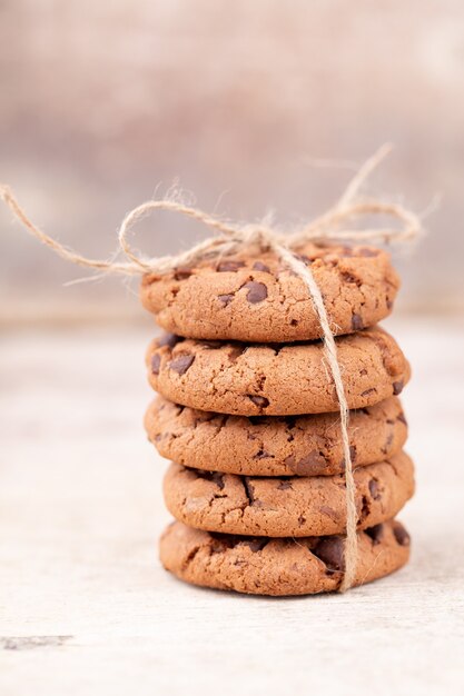 Pile de cookies aux pépites de chocolat sur une planche en bois rustique