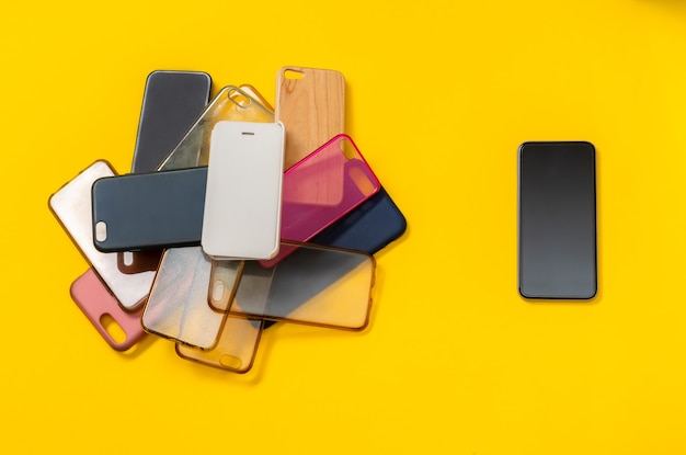 Pile de couvertures arrière en plastique multicolore pour téléphone mobile sur jaune