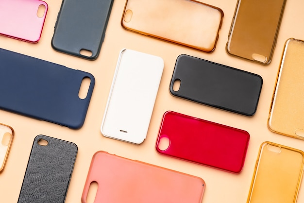 Pile de couvertures arrières en plastique multicolores pour téléphone portable. Choix d'accessoires de protection pour smartphone sur fond neutre. Beaucoup de dos ou de peaux de téléphone en silicone les uns à côté des autres