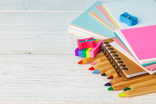 Pile de crayons de couleur et papier sur table en bois