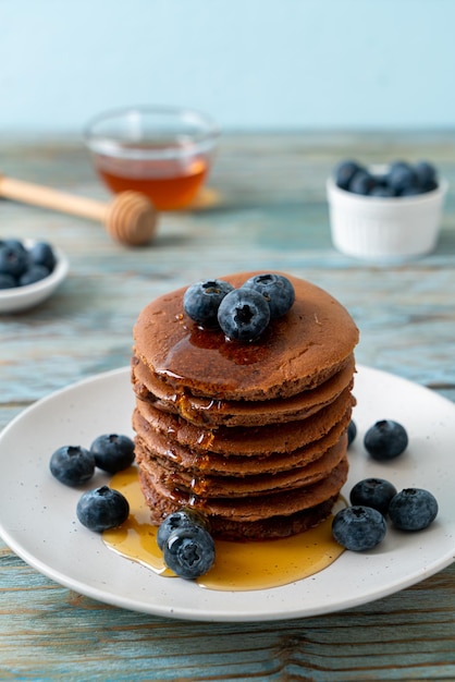 pile de crêpes au chocolat avec myrtille et miel sur assiette