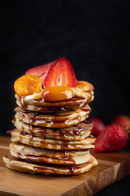 Pile de crêpes au sirop de fraise, abricot et caramel