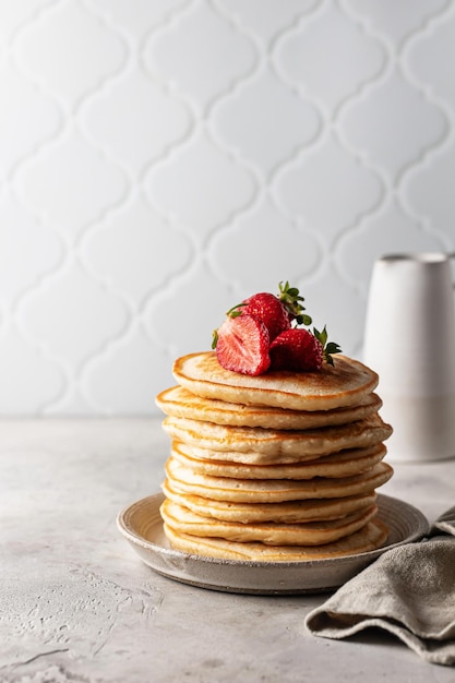 Pile de crêpes aux fraises avec serviette sur fond texturé avec espace de copie Concept de petit-déjeuner fait maison