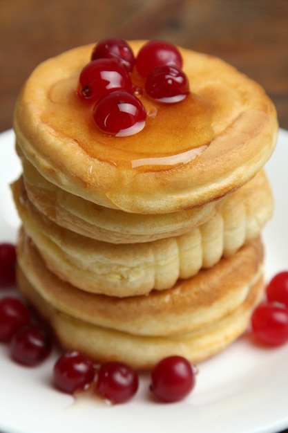 Photo pile de crêpes aux fruits rouges sur une plaque.