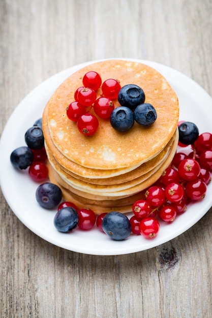 Pile de crêpes aux myrtilles et baies fraîches.