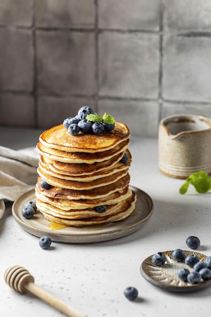 Pile de crêpes aux myrtilles fraîches et au miel