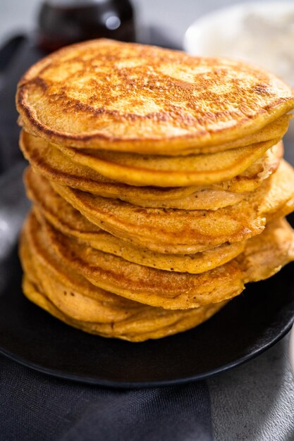 Pile de crêpes à la citrouille fraîche sur une plaque noire