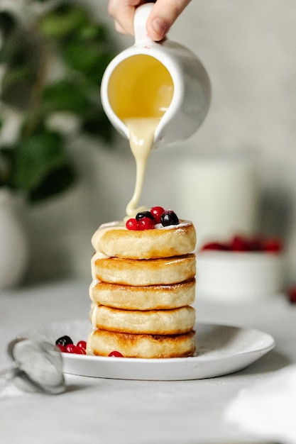 Photo une pile de crêpes avec du sirop versé sur le dessus