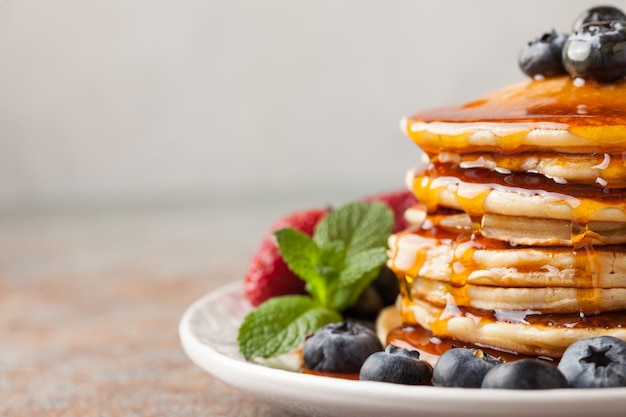 Une pile de crêpes faites maison avec des baies fraîches.