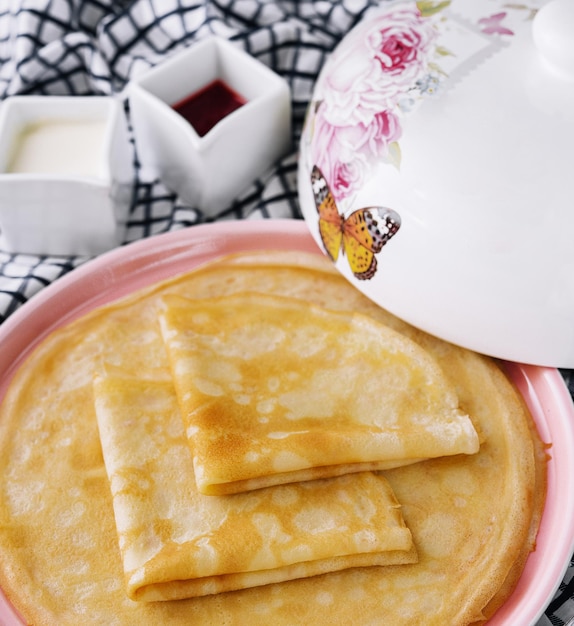 Pile de crêpes fines fraîches sur plaque rose