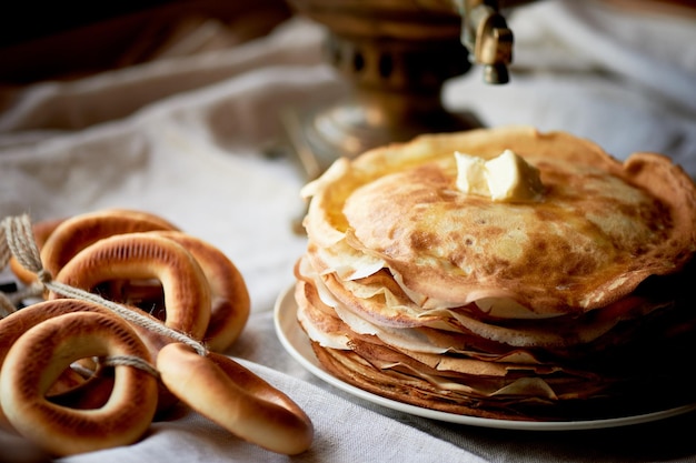 Une pile de crêpes avec un morceau de beurre fondant Tea party russe