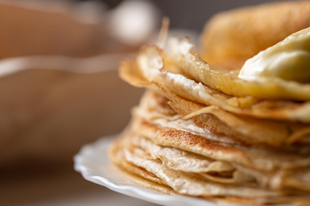 Une pile de crêpes avec un morceau de beurre fondu