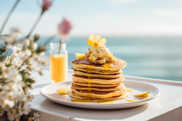 Une pile de crêpes avec un verre de jus d'orange sur la table.