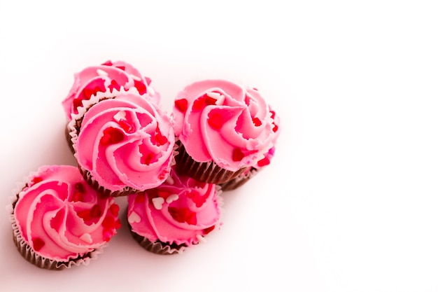 Pile de cupcakes roses avec bague de fiançailles sur le dessus.