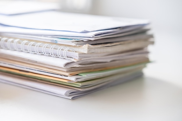 Pile de différents cahiers sur un rebord de fenêtre blanc à la lumière naturelle de la fenêtre