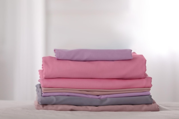 Pile de draps pliés de couleur propre sur le lit