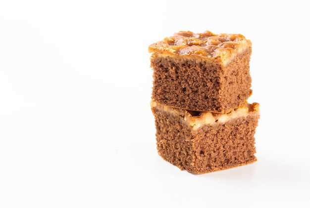 Pile de gâteau au caramel aux noix sur fond blanc.