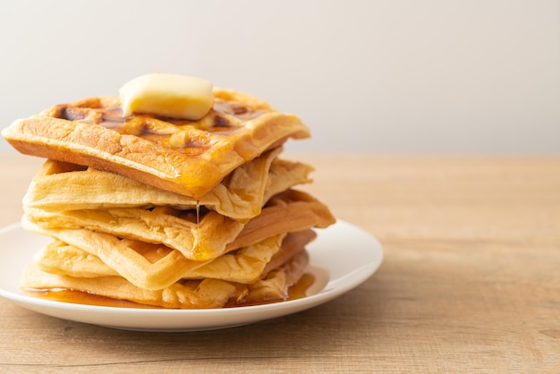 Pile de gaufres maison avec beurre et miel ou sirop d'érable