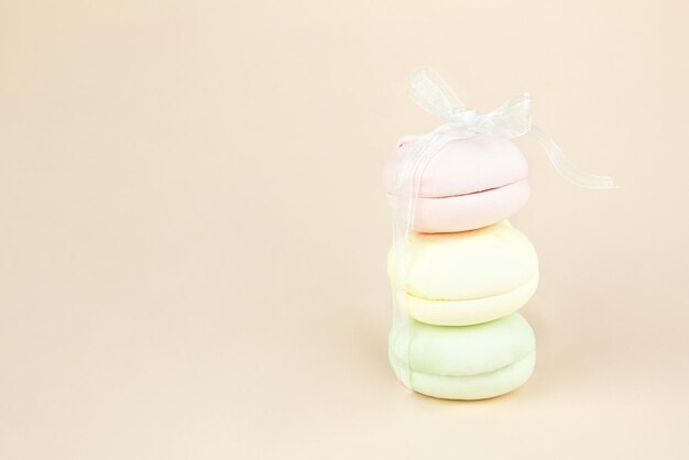 Une pile de guimauves ressemble à un cadeau avec un noeud de ruban blanc Biscuit français Macarons Gâteaux