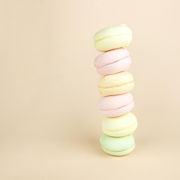 Pile de guimauves ressemble à des macarons macarons cookie français sur fond crème pastel cookies aux amandes colorées couleurs pastel