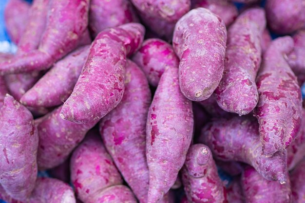 Photo pile d'ignames violettes fraîches à vendre sur le marché