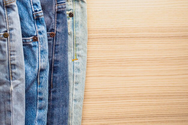 Pile de jeans bleu denim sur fond de table en bois