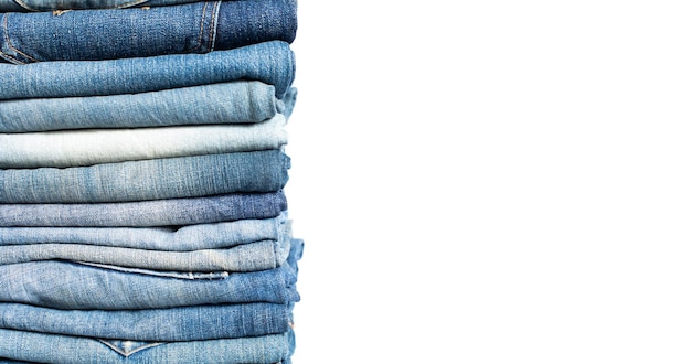 Pile de jeans bleus de différentes nuances Jeans empilés isolés sur fond blanc Bannière de texture de jeans en denim bleu avec espace de copie pour l'arrière-plan de conception de texte Texture de mode en denim de toile