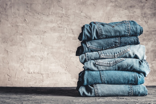 Pile de jeans bleus sur fond gris