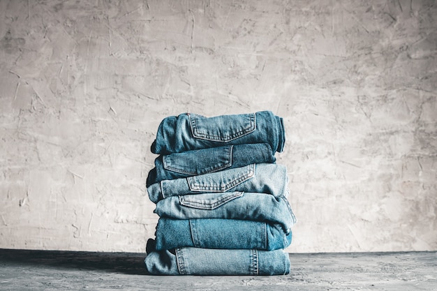 Pile de jeans bleus sur fond gris