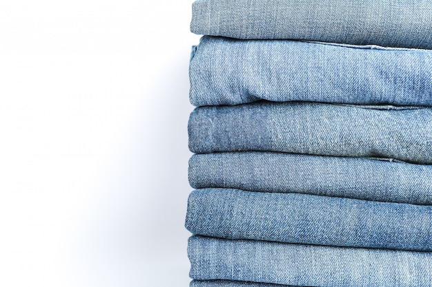 Pile de jeans sur fond blanc, espace pour le texte