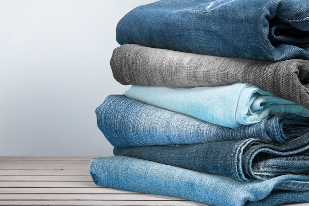 Pile de jeans sur fond de table en bois