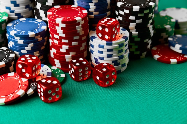 Pile de jetons et de dés de jeu de poker de casino sur la table verte