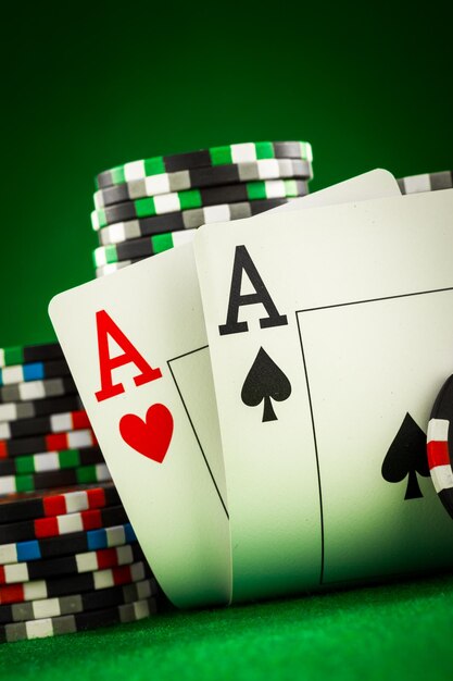 Pile de jetons et deux as sur la table sur la feutrine verte - concept de jeu de poker