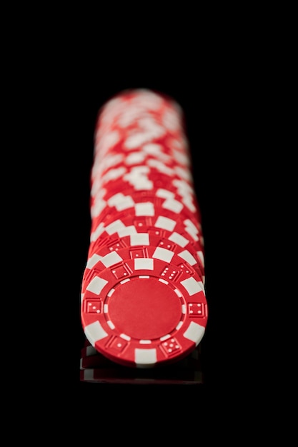 Photo pile de jetons de jeu de casino isolé sur fond réfléchissant noir