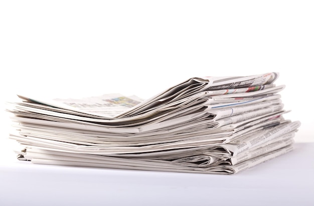 Une pile de journaux sur fond blanc