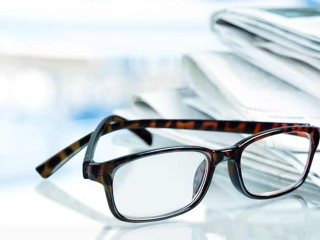 Pile de journaux et de lunettes sur fond