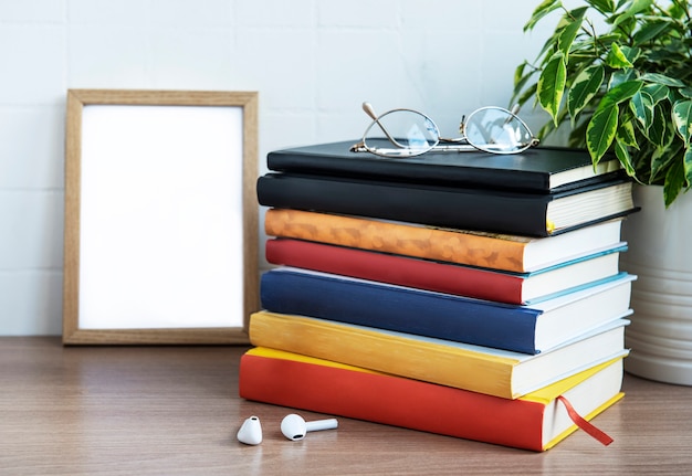 Pile de livres sur le bureau. Divers livres et fournitures de bureau sur la table