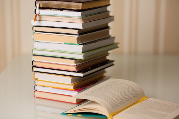 Pile de livres sur un bureau à la maison. Fond rayé beige. Espace libre