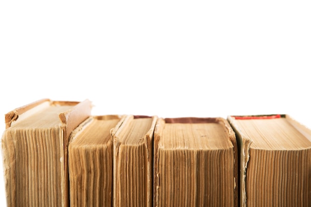 Pile de livres cartonnés anciens et d'occasion ou de manuels isolés sur fond blanc