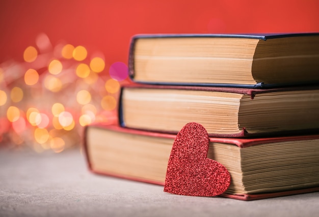 Pile de livres et coeur rouge. Fond romantique avec le livre