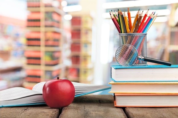 Pile de livres colorés et pomme fraîche