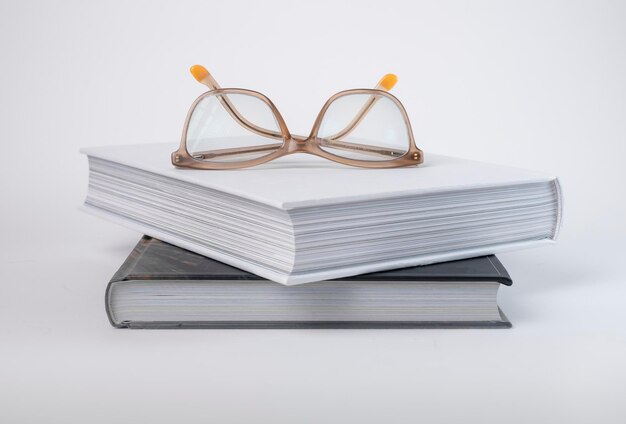 Pile de livres avec lunettes concept d'éducation encyclopédie code biblique ou roman classique sur dos gris...