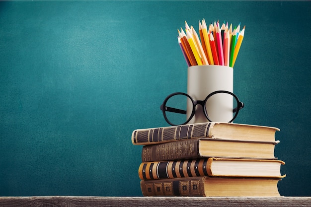 Pile de livres, de lunettes et de crayons vintage, d'éducation et d'apprentissage