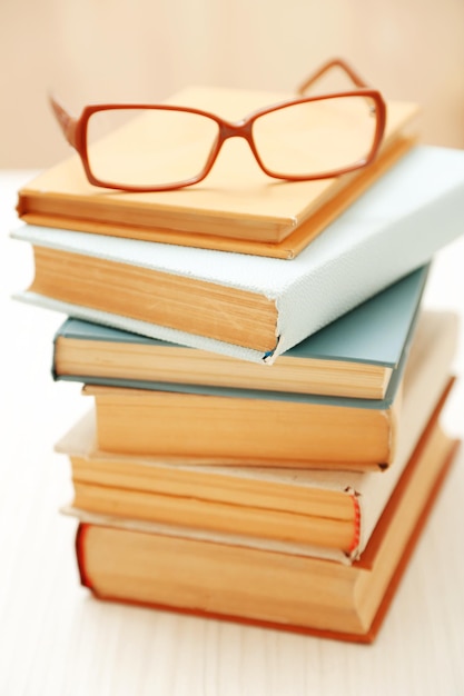 Photo pile de livres et de lunettes dessus se bouchent