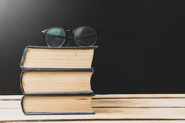 Pile de livres avec des lunettes sur le dessus.