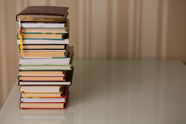 Pile de livres à la maison. Fond rayé beige. Espace de copie