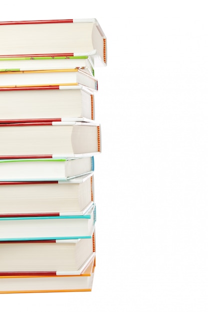 Une pile de livres sur un mur blanc.